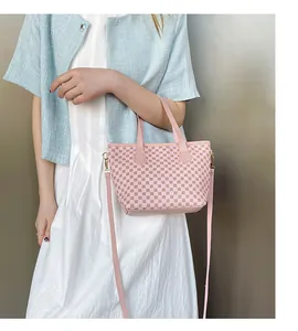 Bolso tote rosa con patrón tejido, asas dobles y correa larga para el hombro detalle