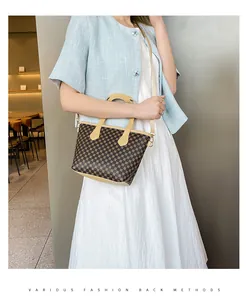 Detalle de bolso bandolera con estampado de círculos, asas en contraste y herrajes metálicos