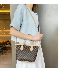 Detalle de bolso tote con patrón vintage con asas de cuero amarillo claro y herrajes dorados