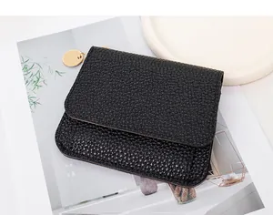 Dettaglio mini portafoglio in pelle nera martellata con tirazip circolare color oro