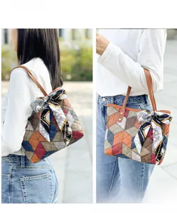 Detail of colorful quilted leather tote bag featuring geometric patterns and a silk scarf