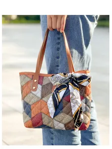 Detail of color-block tote bag with lychee texture leather and decorative silk scarf