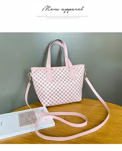 Detalle de bolso rosa con estampado geométrico y correa de hombro de tela desmontable
