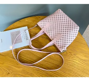 Detalle de bolso tote tejido rosa claro con motivos geométricos y correa para el hombro