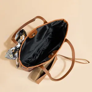 Brown tote bag with silk scarf detail, magnetic closure, and dual shoulder straps