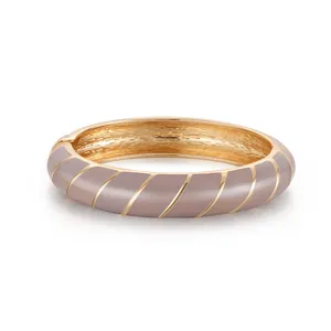 Dettaglio del bracciale smaltato taupe con strisce dorate a spirale e interno lucido