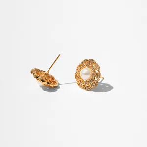 Détail de boucles d'oreilles étoile de mer dorées avec perle blanche et cristaux brillants