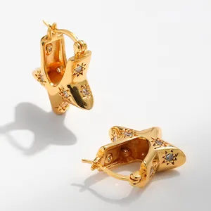 Dettaglio di orecchini a stella placcati oro 18K con pavé di zirconi brillanti e lucidi