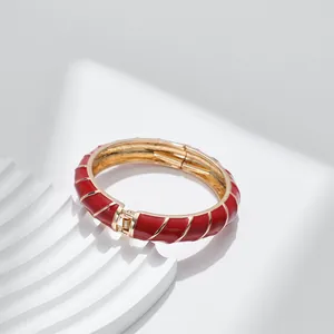 Dettaglio del bracciale a spirale in smalto rosso con finitura dorata su base