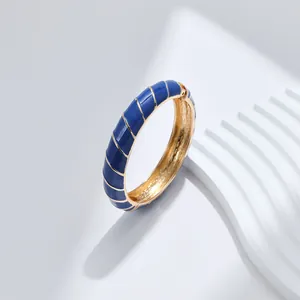 Dettaglio del bracciale in smalto blu con spirali dorate e chiusura a cerniera