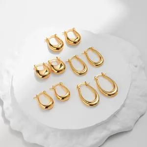 Orecchini a cerchio spessi placcati oro 18K in tre misure su vassoio di pietra