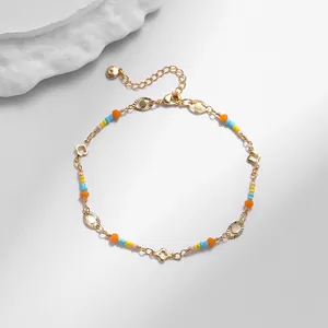 Detalle de la tobillera bañada en oro de 18K con cuentas de colores y amuleto ojo