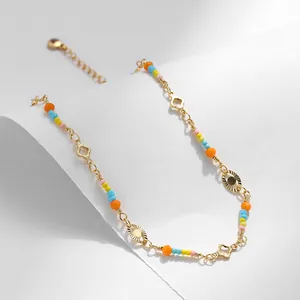 Detalle de la tobillera bañada en oro de 18K con cuentas de colores y amuletos ojo