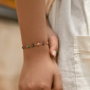 Gold chain bracelet for women featuring multi-color evil eye heart charms on wrist