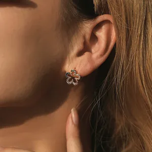 Close-up of five-petal flower stud earring in 18K gold with colorful rainbow zircons