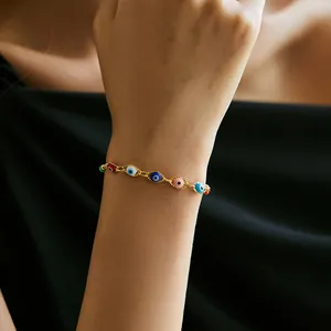 Macro detail of 18K gold-plated evil eye bracelet with colorful beads on wrist
