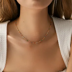Gros plan d'un collier en laiton plaqué or 18 carats avec perles arc-en-ciel colorées