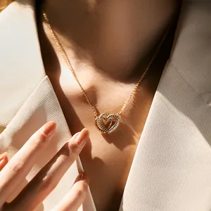 Κολιέ με διπλή καρδιά επιχρυσωμένο 18K με ζιργκόν φορεμένο από μοντέλο σε λευκό