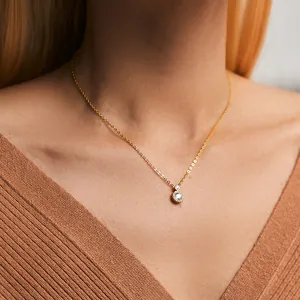 Close-up of 18K gold plated necklace with a sparkling halo diamond pendant on a model