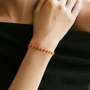 Böhmisches 18K vergoldetes Kettenarmband mit orangen Perlen am Handgelenk