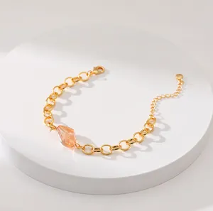 Dettaglio macro del bracciale a catena dorato 18K con pietra ambra e chiusura a moschettone