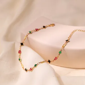 Elegant gold-plated anklet with multi-colored gemstones on a soft textured background