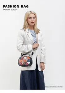 Detail of color-block geometric embroidery and wide strap on crossbody bag