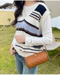 Cylindrical brown crossbody bag with quilted rhombus pattern and flower detail