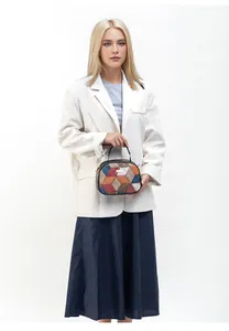 Detail of color-block geometric pattern crossbody bag with stitch texture and metal plaque