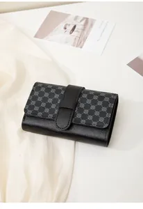 Detail of minimalist women's mini wallet showing textured black leather and clover pattern