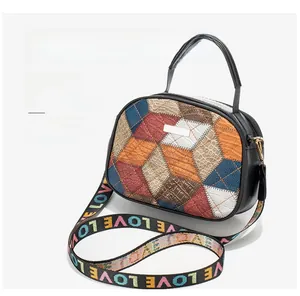 Detail of multi-color patchwork leather crossbody bag with patterned LOVE wide strap