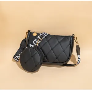 Détail du sac à bandoulière noir matelassé avec ferrures dorées et petit porte-monnaie