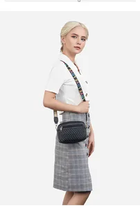Detail van zwarte gewatteerde crossbodytas met gekleurde LOVE-band op model