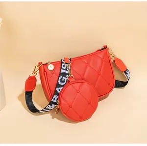 Détail du sac à bandoulière rouge matelassé avec motif cœur et large sangle à motif