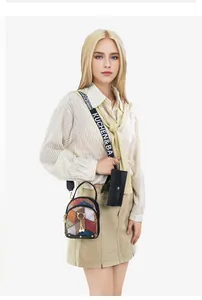 Detailed view of crossbody bag with color-block pattern and pearl cat charm on wide strap