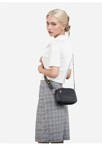 Detail van zwarte crossbodytas met chevron-stiksel en kleurrijke LOVE-band