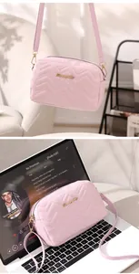 Pink quilted shoulder bag with S-logo and chain strap on a white laptop keyboard