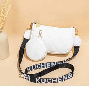 Détail d'un sac à bandoulière blanc matelassé avec petit porte-monnaie et sangle large