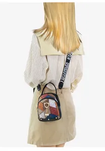 Close-up of quilted pattern handbag with cat-shaped metal ring and pearl charms detail