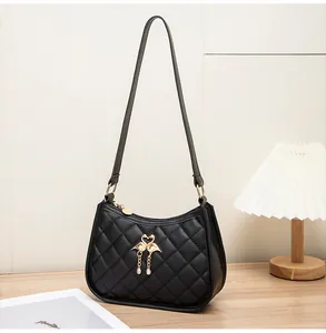 Detail der schwarzen gesteppten Schultertasche mit goldenen Schwanen-Beschlägen und Ketten