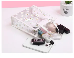 Detail of transparent PVC daisy crossbody bag showing spacious interior with daily essentials