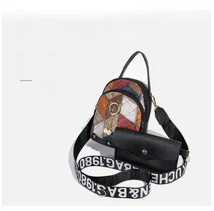 Close-up of quilted crossbody bag with pearl cat charm and wide woven letter strap