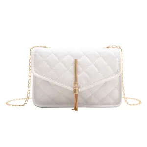 Elegant white quilted crossbody bag with gold chain strap and metal tassel fringe detail