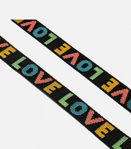 Détail de la bandoulière tissée avec lettres LOVE colorées et doubles coutures renforcées