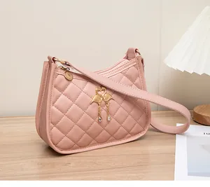 Detailansicht der rosa Stepptasche mit goldenem Schwanenanhänger und Kristallschmuck