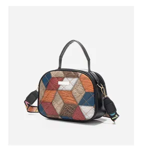 Detail of cubic crossbody bag featuring geometric patchwork leather and woven strap