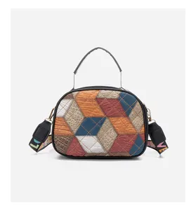 Close-up of color-block cube bag featuring mixed crocodile and snake textures