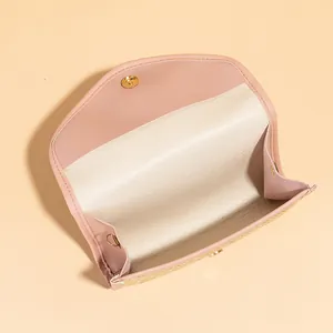 Pink woven crossbody small square bag with gold metal buckle and interior details