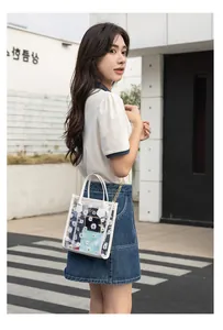 Detail of transparent PVC crossbody bag with white daisy print and gold chain strap