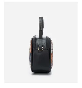 Detail view of the vintage crossbody bag with dual gold zippers and black leather texture
